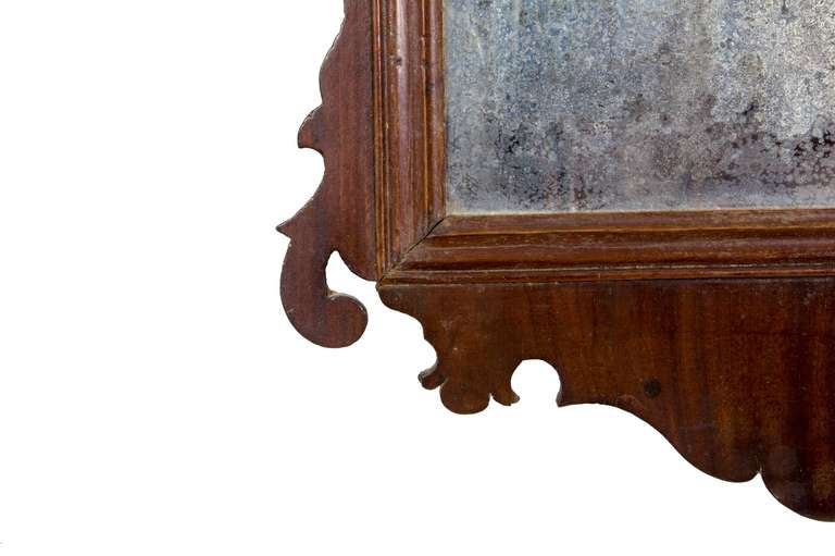 This small mirror retains its original glass. Its Silhouette is perfection and the backboard appears original.