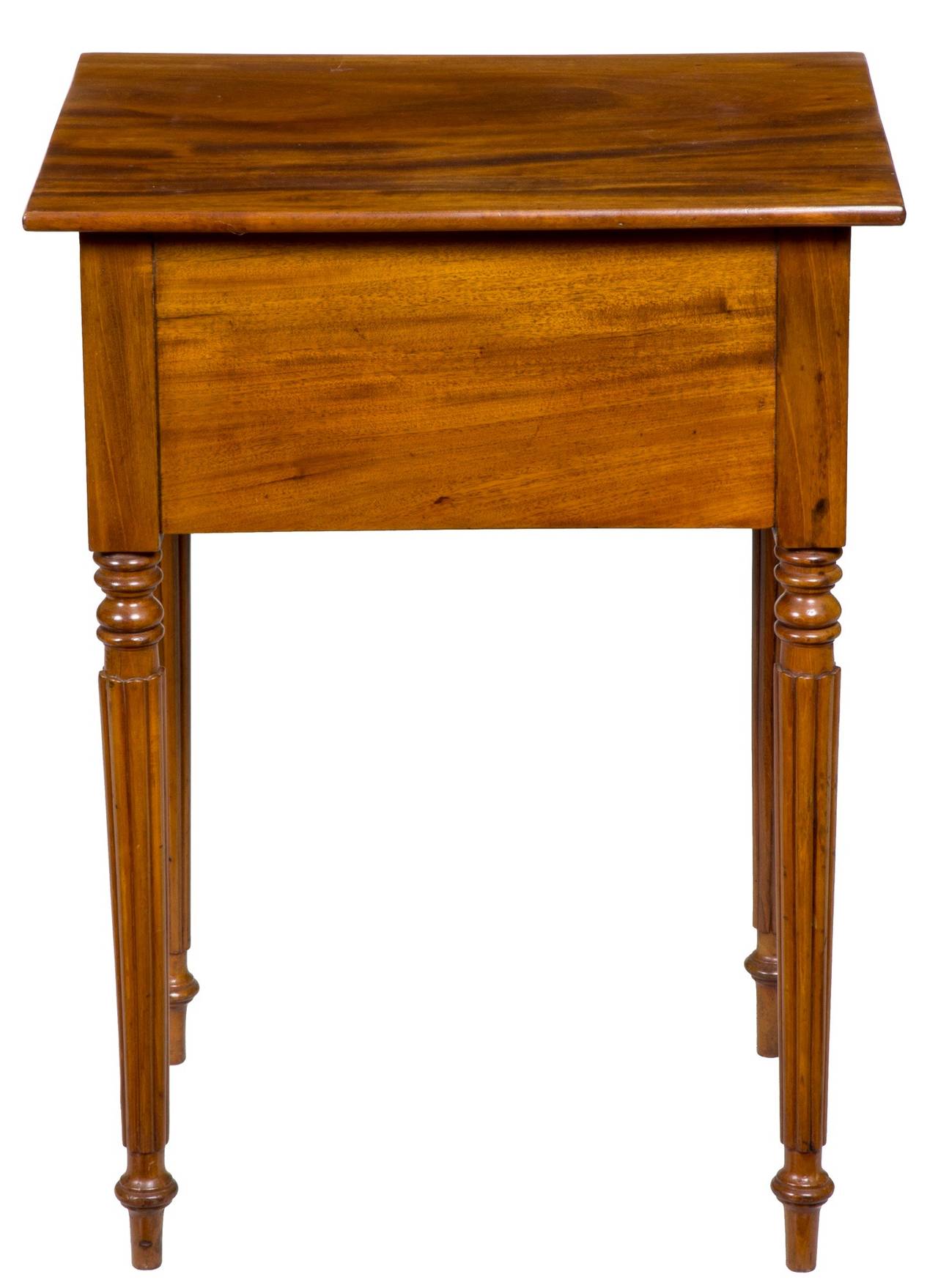 This is a beautiful blond mahogany which almost has a walnut look. The striping of the wood is highlighted by this blond color background, making this table quite light in feel. The tapered reeded legs are done to perfection; note the top of each of