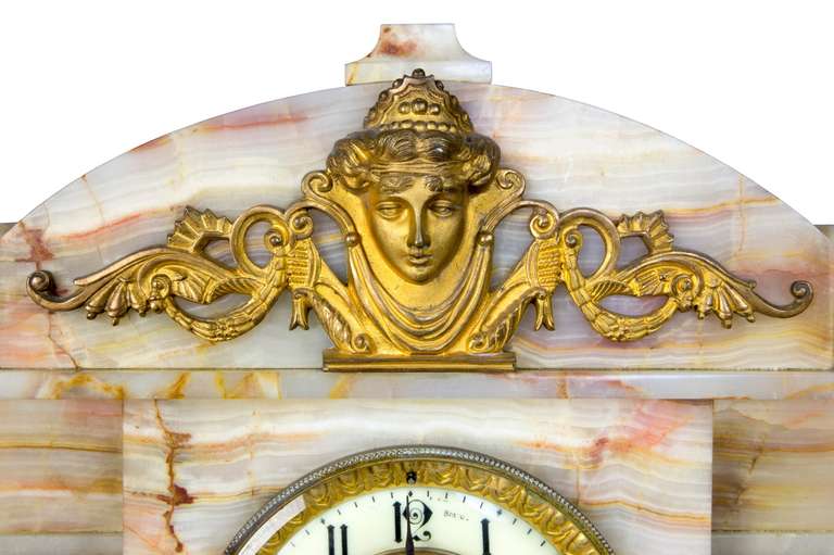 British A Victorian Variegated Marble Mantel Clock with Figural Mounts, circa 1880-90