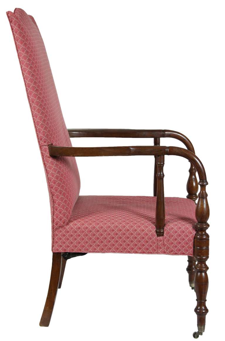 There is a grouping of these large lolling chairs that came out of Portsmouth, and comparison will show that this is one of the best. The arms are beautifully molded, in addition to the secondary vertical arm support, which is often unturned. While