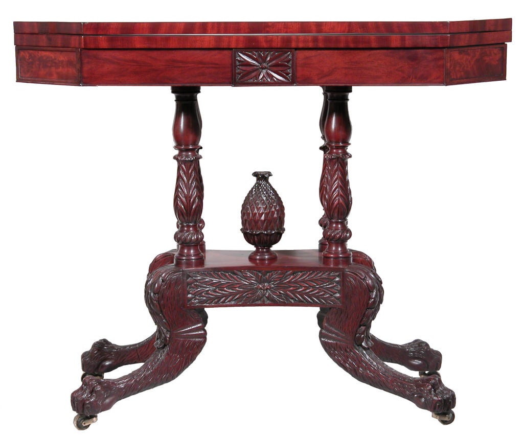 This card table represents the height of the Empire period with fabulous carving throughout. We have seen several drop-leaf tables of this form, but this is the only card table we have seen. The top which is composed of dramatic mahogany veneers