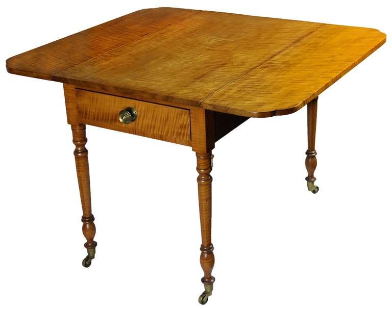This fine tiger maple pembroke table is entirely composed of quartered maple which has taken on a mellow golden tone. The top is one unjoined board with related sides, all no doubt, of the same tree. The legs also are striped and quite vigorously