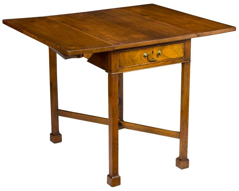 This walnut table is a Classic example of the Marlborough leg with cross stretchers. This is a heavy table for its small size, as it is of solid walnut and quite dense. This table is in pristine condition down to its original brass. Note the use of
