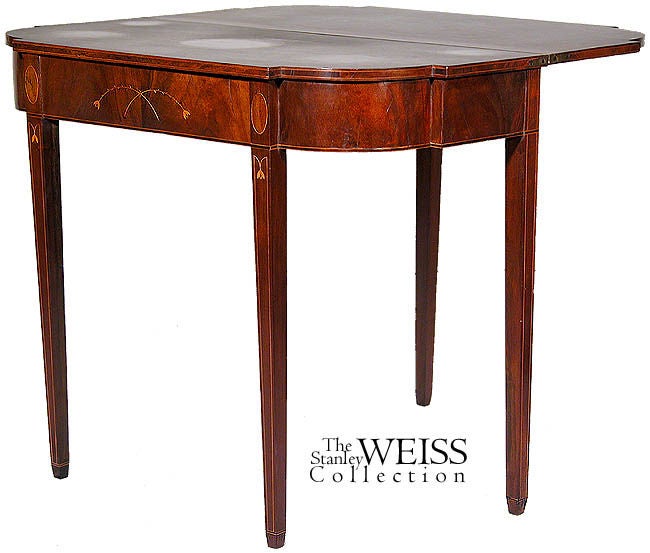 This table is associated with the Thomas Howland school in Rhode Island, primarily on the basis of the stylized sprigs. This is a fairly special table, because unlike many others, it has bellflowers on the legs as well as an oval patera in the