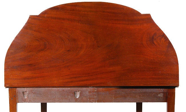 This finely constructed card table is composed of a rather unusually large and beautiful central oval of crotch satinwood meticulously edged with a variegated molding (which is not common) all of which is framed by a central mahogany panel. Flanking