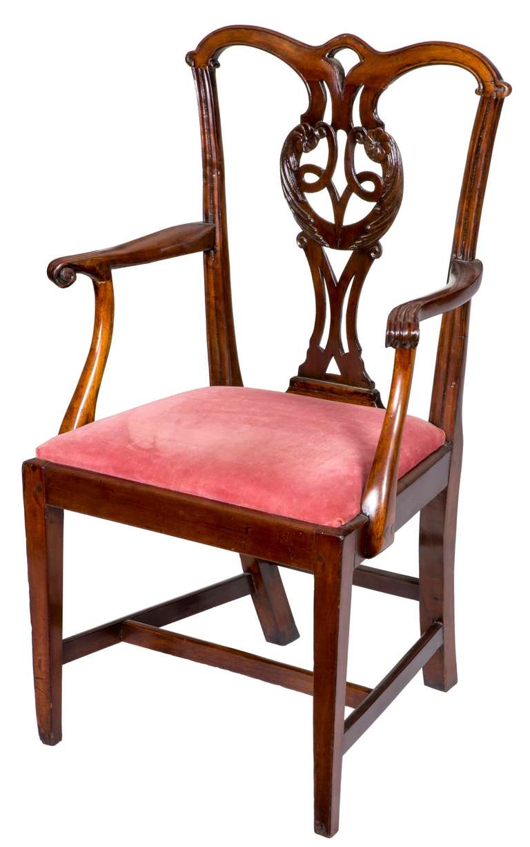 The carved backsplat on this chair is beautifully developed and makes a very important statement. The chair itself is transitional, leaning toward the Hepplewhite period with its square, tapered legs, retaining its their original stretchers (which