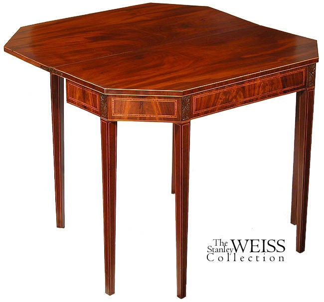 Fine inlays, six carved pateras (one over each leg) and highly figured mahogany in a restrained Hepplewhite form define this rare and most elegant card table. Impeccable condition throughout. This is a superb example of English craftsmanship and