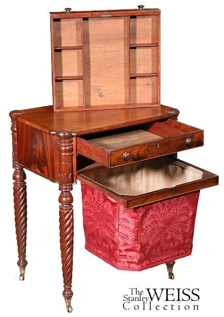 This sewing basket, supported with nicely tapered spiral legs, has just above it, acanthus leaves, signifying its Salem provenance. It is a three-drawer sewing table with original wooden pulls. We have reupholstered the bag with an appropriate