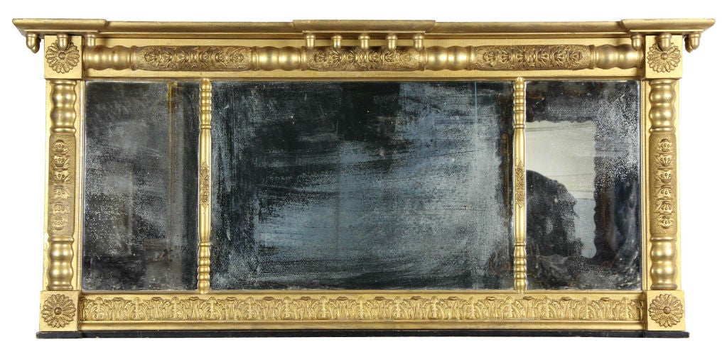 This overmantel mirror is fully developed with acorns and carved embellishment on all its gilt surfaces. The gilt is original, as are the mirrors and backboards.