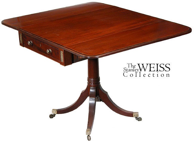 This small Pembroke table is finely crafted with a beautifully figured mahogany top, which is inlaid with satinwood and ebony line inlay, around a sizable rosewood banding. The saber legs also have ebony line inlay on the top of each saber. Unlike