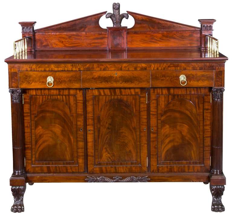 This sideboard is the finest of its type produced in New York during the first quarter of the 19th century. It has many carved elements not seen on others, and a magnificent choice of striking ribbon mahogany. Note the support columns that flank the