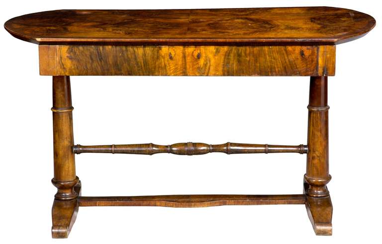 This sofa table, of small-scale, has a magnificent crotch walnut top. It is beautifully bookend-matched and glows from light to dark with magnificent burl. This table has one long drawer and is finished on all sides, so it can even function as a