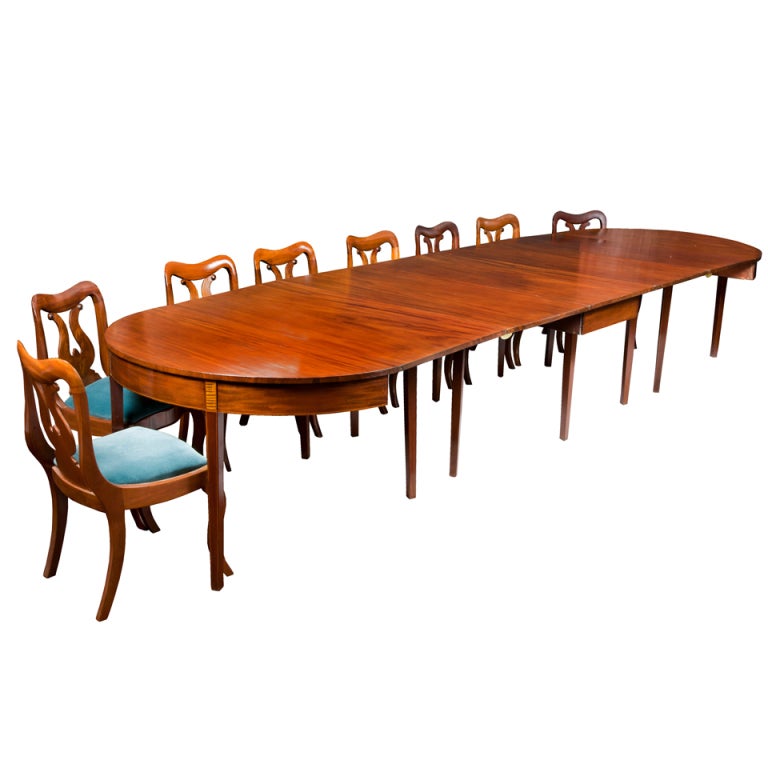 This table is composed of magnificent heavy solid ribbon grained mahogany boards. Note the consistency of the striped ribbon graining throughout the entire top. (See detail.) This banquet table has leaves that are attached to each of the D-ends, as