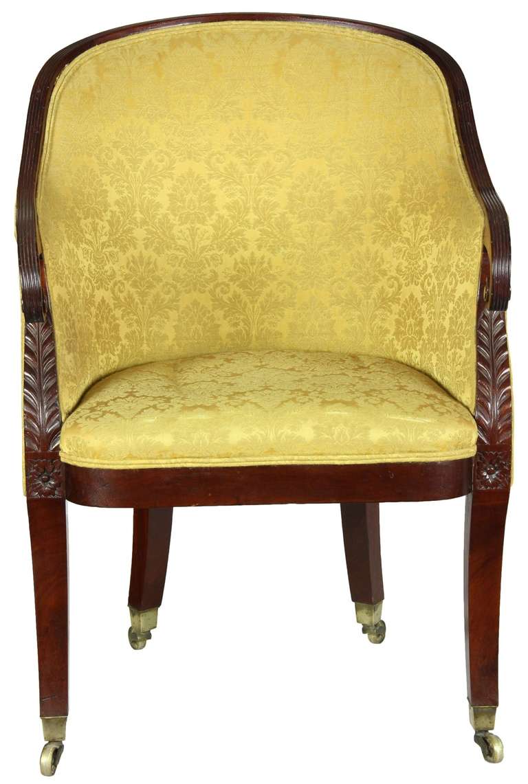 This chair is beautifully sculpted in form and design. Note the scrolled arms that reach out and the deeply carved acanthus just below. The seat has a bowed front and all legs are on original casters. There are no breaks or alterations and although