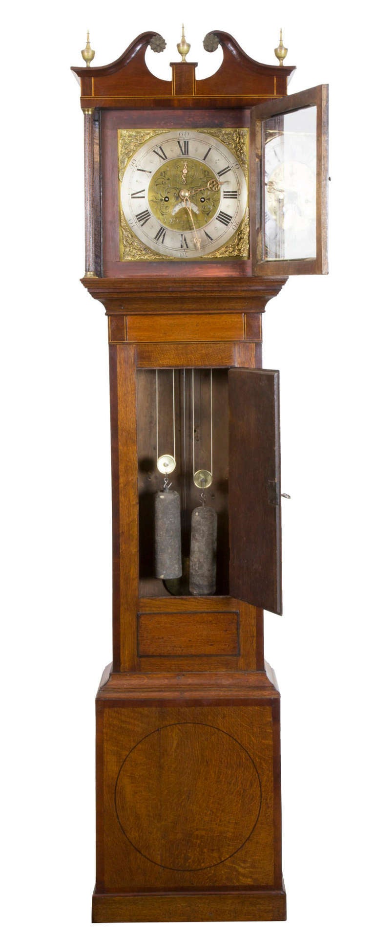 This is a small-scale clock with a lot going for it. Note the inlaid conch shell and the inlay work around the door. The inlay work is quite restrained but it's there throughout. Note the swan neck pediment with original old brass rosettes. The