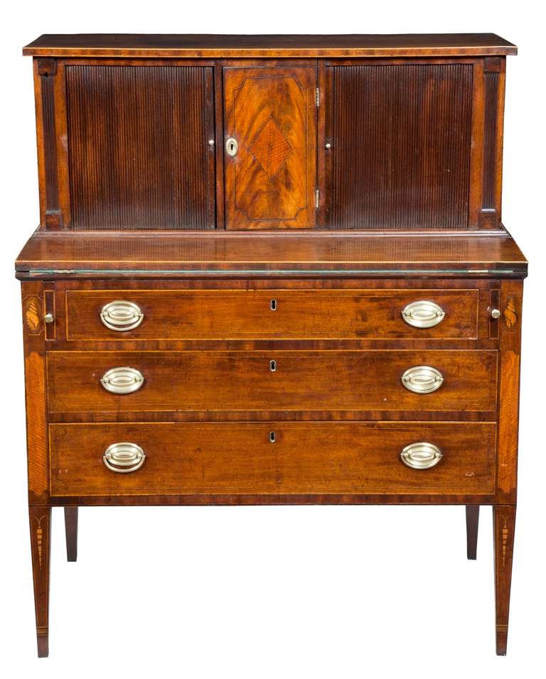 This tambor desk is in exceptionally fine condition down to its original brasses and wonderful inlaid embellishments.   The entire piece retains an old historic surface, which has been waxed through the years.   

This piece is illustrated on a