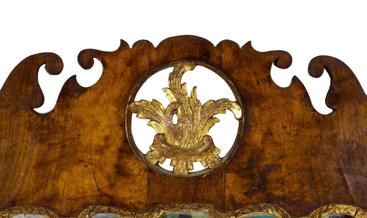 A fine Queen Anne walnut parcel-gilt mirror with elaborately scrolled crest and apron, ex. Joseph Kindig, Jr., probably Philadelphia, circa 1760.

This mirror is composed of beautifully aged walnut with an older surface and its original gilt