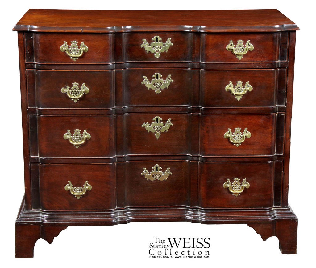 This is a 38 in. wide block front chest with a radiant mahogany red shining through its dark old surface (see detail) that only a period piece of mahogany from Cuba which hasn't been sanded down and refinished. The brasses are the original thin,