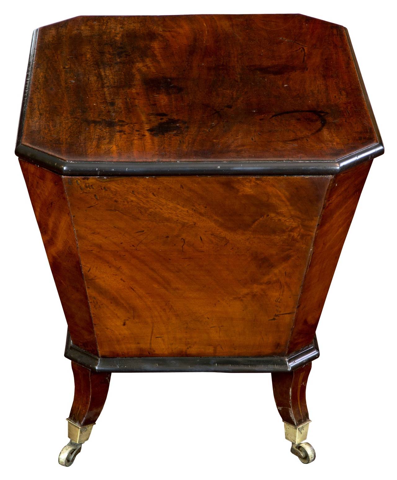 This mahogany cellarette has a solid mahogany top showing years of staining which have been over-polished time and again. The case has a wonderful 18th century feeling and the feet, which are all original including casters has a light wood inlay.