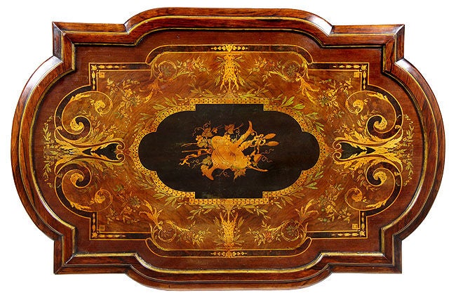 This monumental center table is grand in scale and is elaborately inlaid both on its top and fully around its apron. What sets this table apart from all others we have seen are the fabulous wolf heads. The oxidation is magnificent on these, as it is
