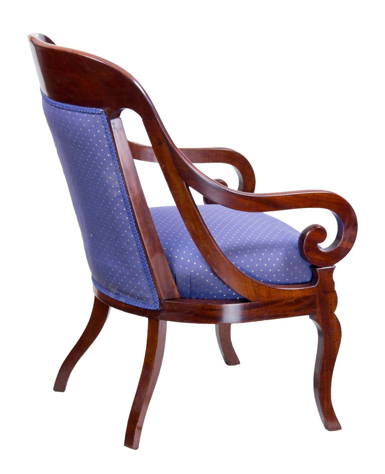 This is a commodious and comfortable armchair. The style is superb with scrolled arms and additional side supports that taper into the front arm supports. The rear legs have a beautiful splay and the figured mahogany apron below the seat is bow