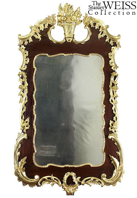 These gilt mirrors make a sensational statement with elaborate carving on a mellow, well-aged mahogany substrate. Pairs are extremely rare, and these are of exceptionally large size, retaining their original wavy aged glass. There are no breaks or