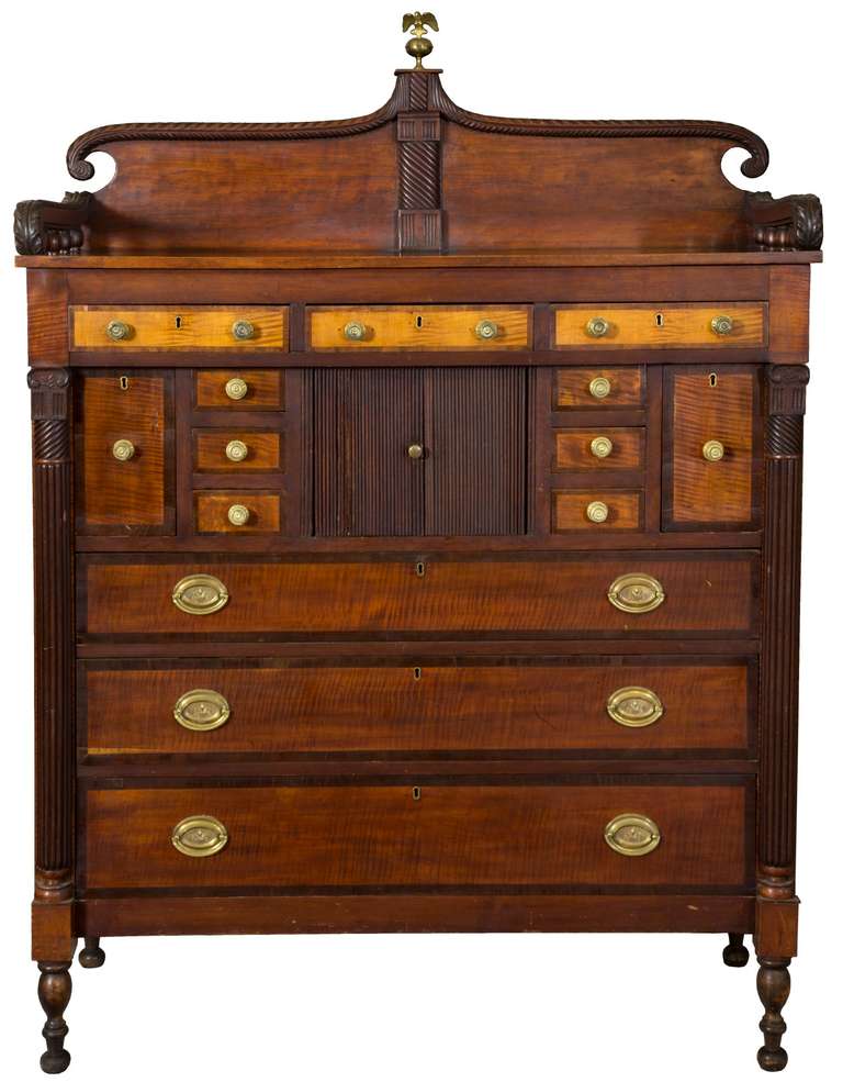 This chest exhibits a beautiful scrolled backsplash with carving and original gallery retaining an original surface. The multi-faceted drawer configuration is a tour de force of bottle drawers, silverware drawers and original tambour; flanking all