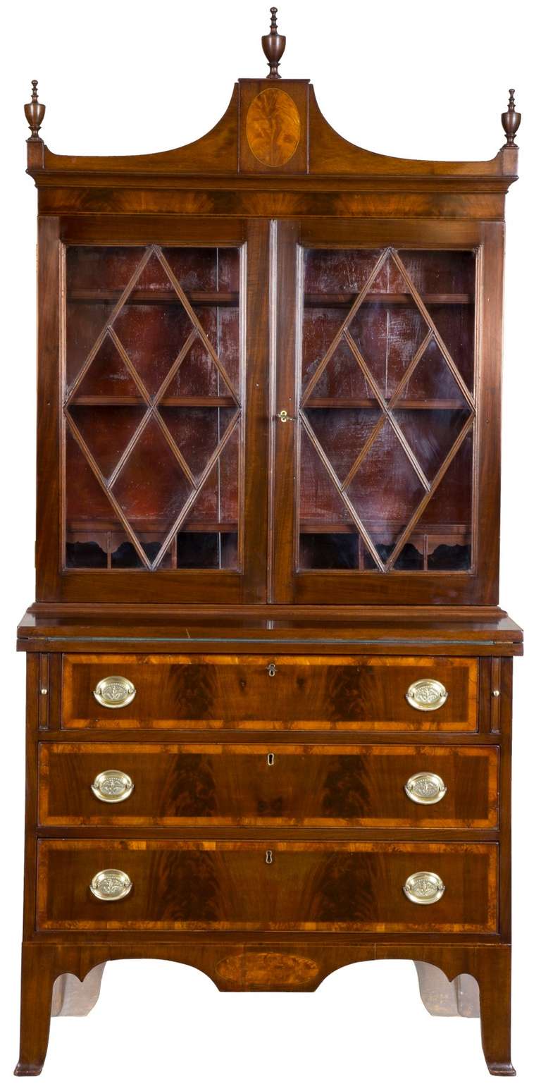 This secretary is of small scale, almost diminutive, at 36 inches wide. It is a real treasure that has all the bells and whistles. It has a beautiful inlaid oval in the rather tall pediment and bears its original finals, which are almost always