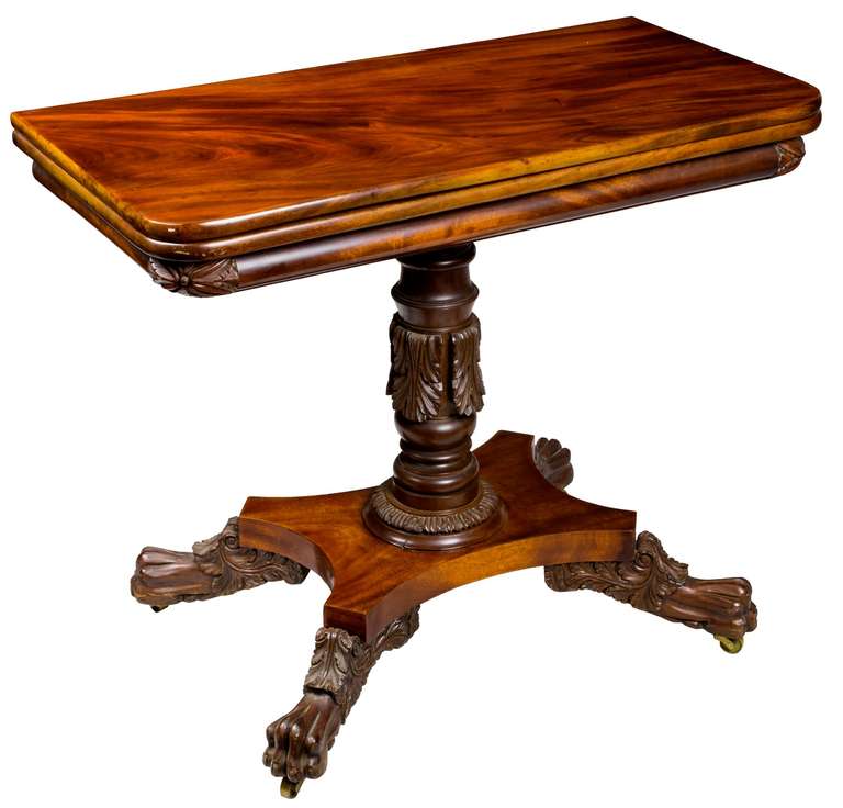 This high style classical card table has a very narrow convex apron with carved corners and top leaves of dense one board mahogany of notable figure, the turned base with acanthus molding is typical of work attributed to Anthony Quervelle (see the