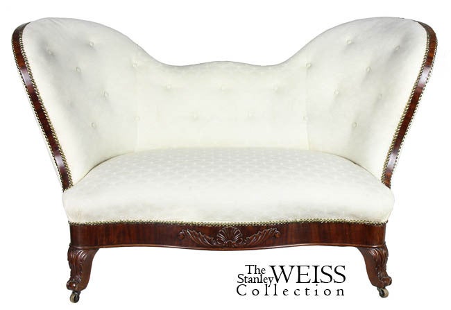 This rare form is of small scale and embellished with figured mahogany both around the sofa silhouette as well as the skirt which features a carved shell, etc.

The french style feet are finely carved and the rear two are clustered somewhat closer