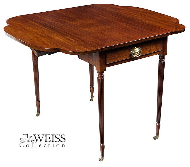 This fine Sheraton mahogany pembroke table of small-scale is composed of a highly figured solid mahogany top with clove leaves and delicate Sheraton legs on original casters. It is typical of the early New York Phyfe school and is almost identical