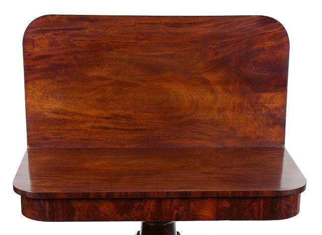 This is a superb classical table with strong deeply carved column supported by dolphins that span the width of the table graciously. These elements retain their original surface. The figured mahogany tabletop and apron were cleaned, revealing the