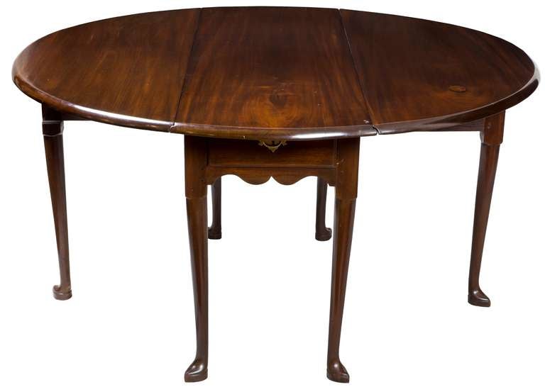 The wood on this table is superb. The leaves are heavy to the weight, which are composed of beautifully figured Cuban mahogany. Few of these dining tables have a drawer, and this has one that’s all original. The legs, we feel, are Rhode Island in