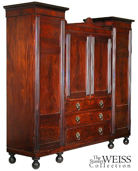 This large-scale linen press is composed of three basic elements: two side closets who doors fully open for hanging clothes and a midsection with pull-out clothes slides and large drawers below. While this piece is quite large, it disassembles into