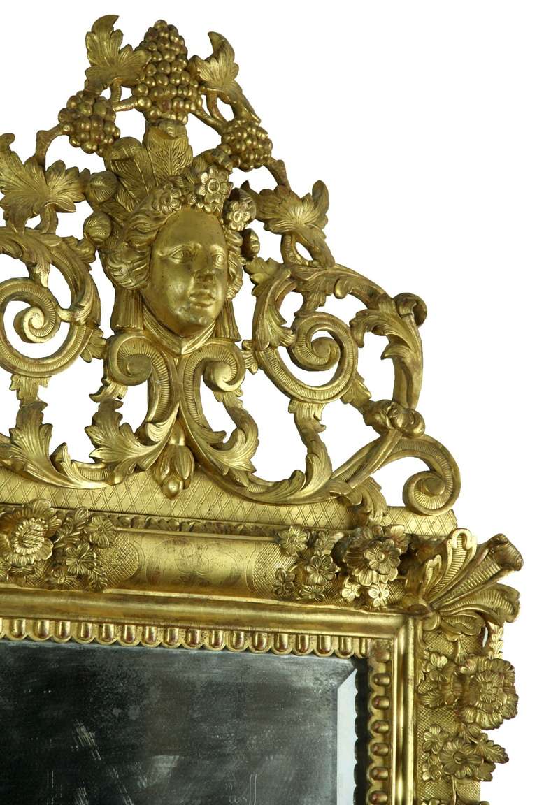 This is a commanding mirror of the first order. In many ways, one has to think of this as a painting, as it’s a sculptural work of art that would complement a sumptuous decor. Its gilt is all original and the carving is a tour de force. Note images