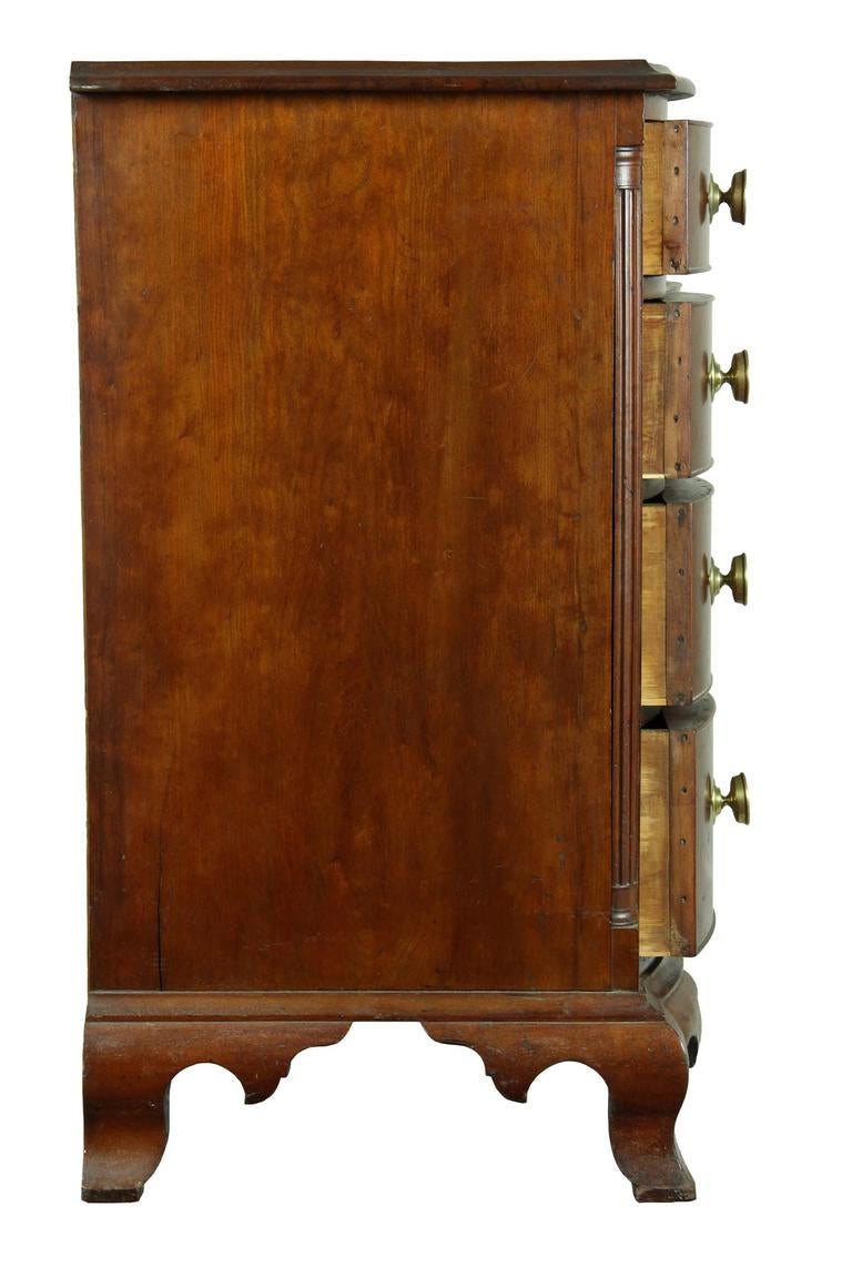 This chest is of robust size which suggests that it should be considered a commode and has a very warm and strong feeling due to the aged and ambered cherrywood along with the strong oxbow/serpentine drawer fronts. This chest belongs to a grouping,