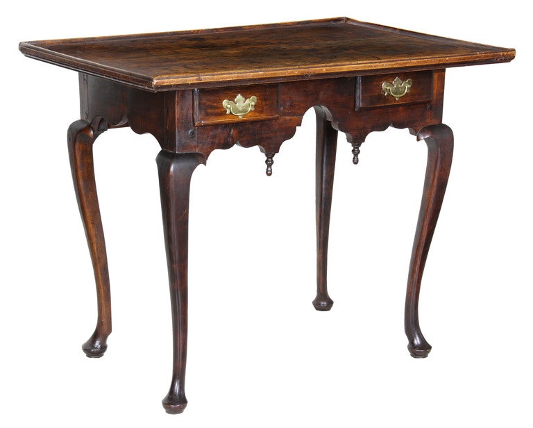 This is a rare survivor with its original brasses that is probably one of the most elegant and diminutive tea tables created in the period. Note the beautiful skirt, which is similar to many New England highboy bases. (See the Queen Anne Tiger Maple