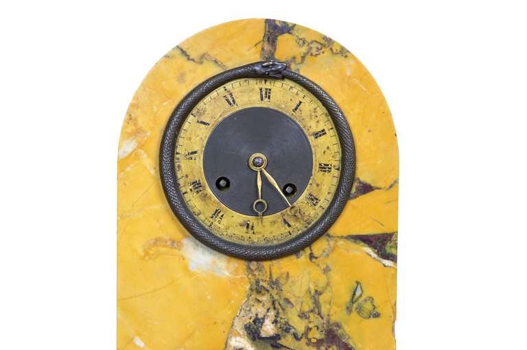 The mountings on this clock are all bronze, with a magnificent bezel depicting the Ouroboros (a classical symbol of a snake eating itself, often associated with eternal regeneration).   The marble is of a solid block and a beautiful piece of stone. 