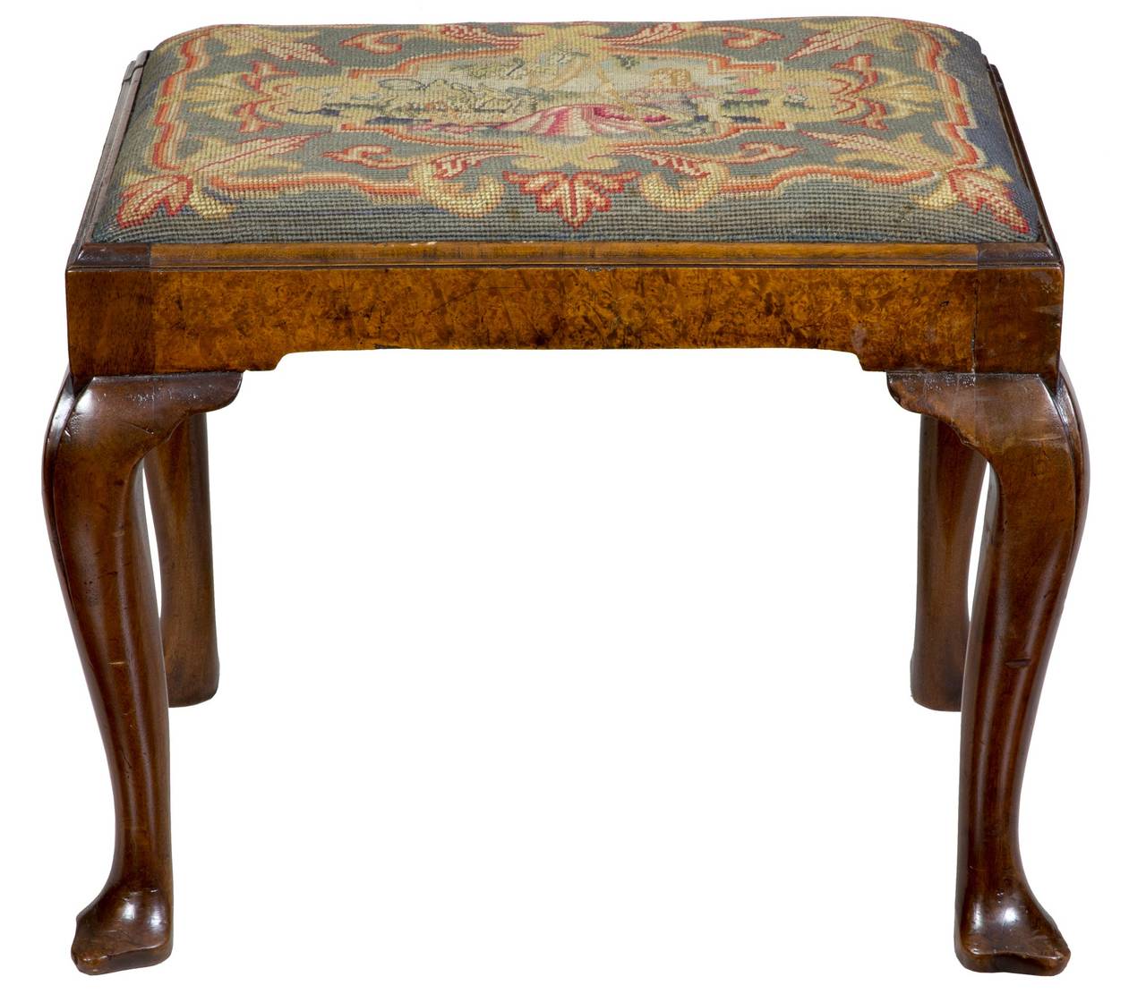This footstool absolutely appears 18th century, but is a later, mid-19th century example, as these were quite popular and made through the century. The walnut is outstanding and has an old wax surface. The tapestry upholstery is in excellent