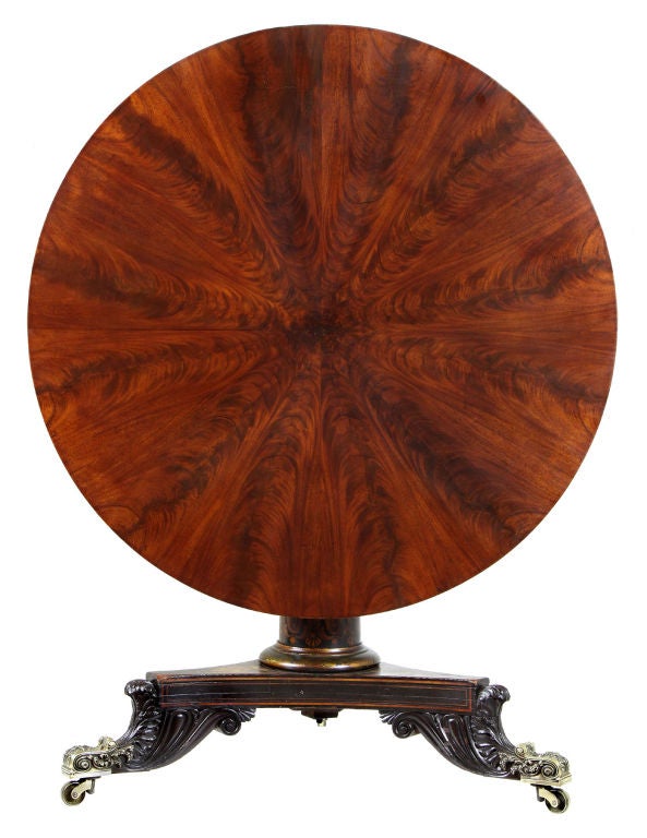 This center table is a beautiful example of Baltimore work with a magnificently figured top. The base retains all its original stenciling and surface. The carved feet are exuberant and the casters fully developed, and of the exuberant type often