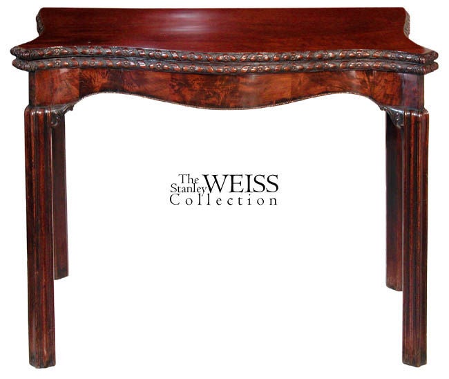 This is one of the finest English card tables we have handled. The top leaves are beautifully figured mahogany, the edges of which are superbly carved. American models of this type were copied in Newport, and those carved edges never come close to