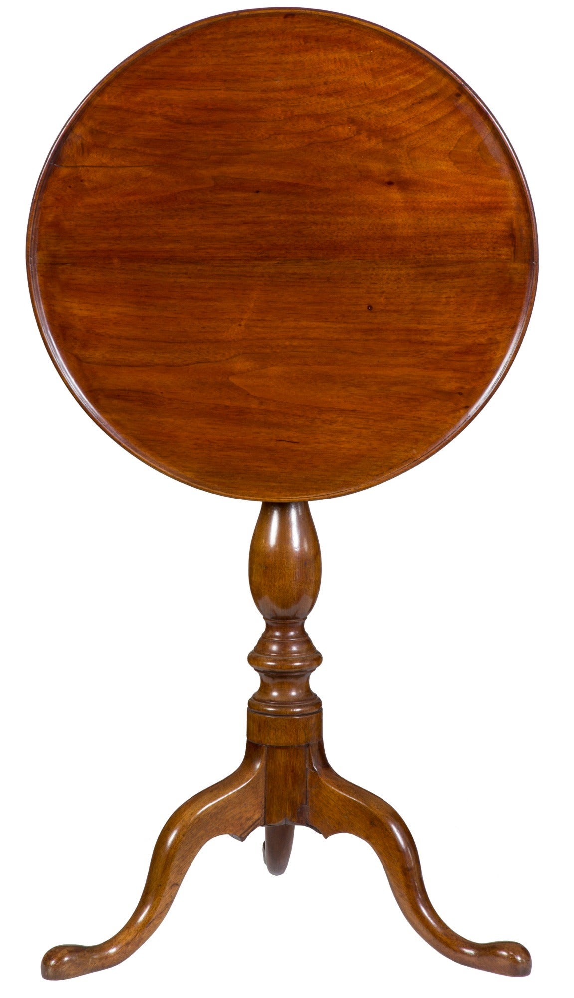 This small tilt-top is an early one, evidenced by its walnut wood choice. It has the desirable dish top and nicely formed cabriole legs. The central support is a traditional baluster, upon an unusually turned base. Small tilt-tops are highly