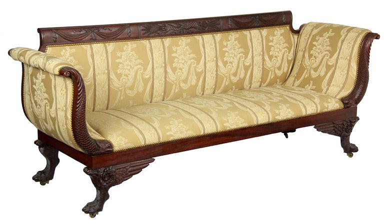 This sofa has it all. It retains the finely carved Phyfe tablets that compose the crest rail, and instead of the usual reeded arm supports, finely carved dolphins are employed. Note the deeply carved scales, et al. This certainly is the work of a