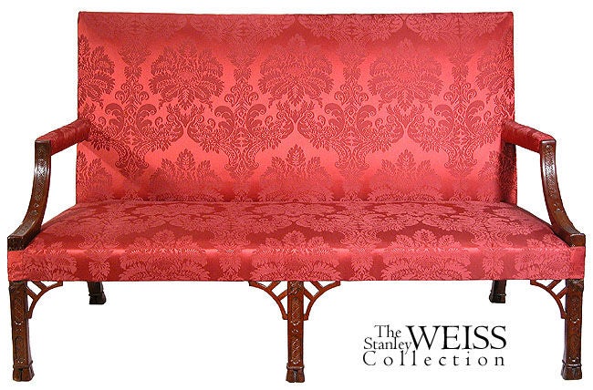 This is an extremely fine settee with beautifully raked rear legs and classic carving throughout. For a related piece in the Chinese Chippendale style, see Colonial Furniture and note the termination of the feet. This settee has been reupholstered