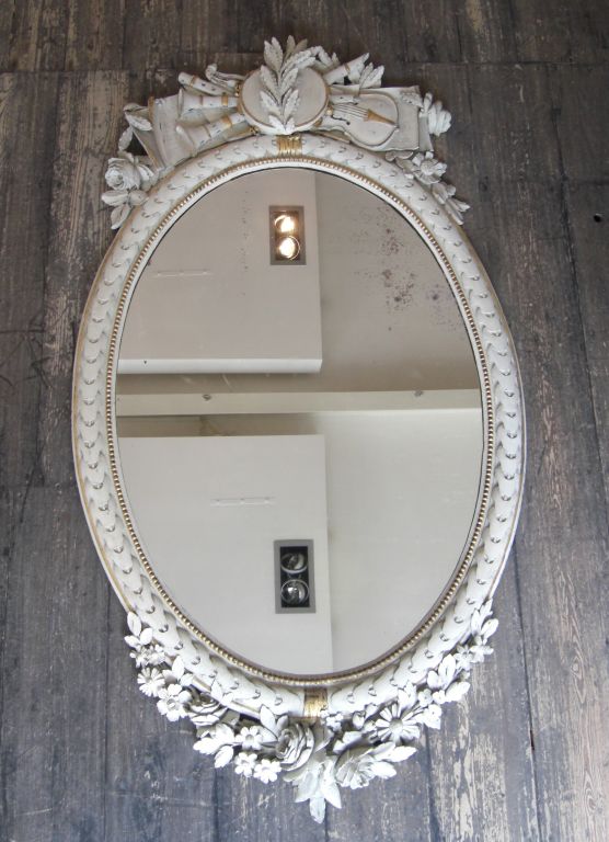 A Pair of Carved and Painted Oval Mirrors