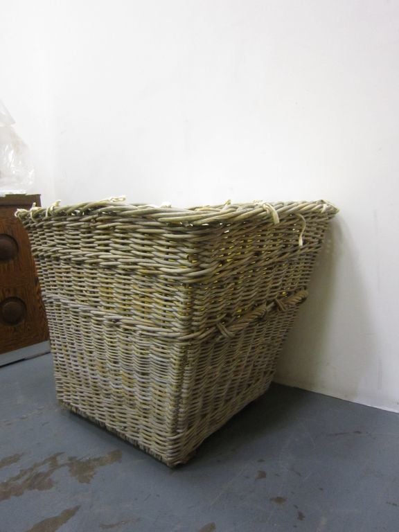 A large wicker log basket, lined and on castors.