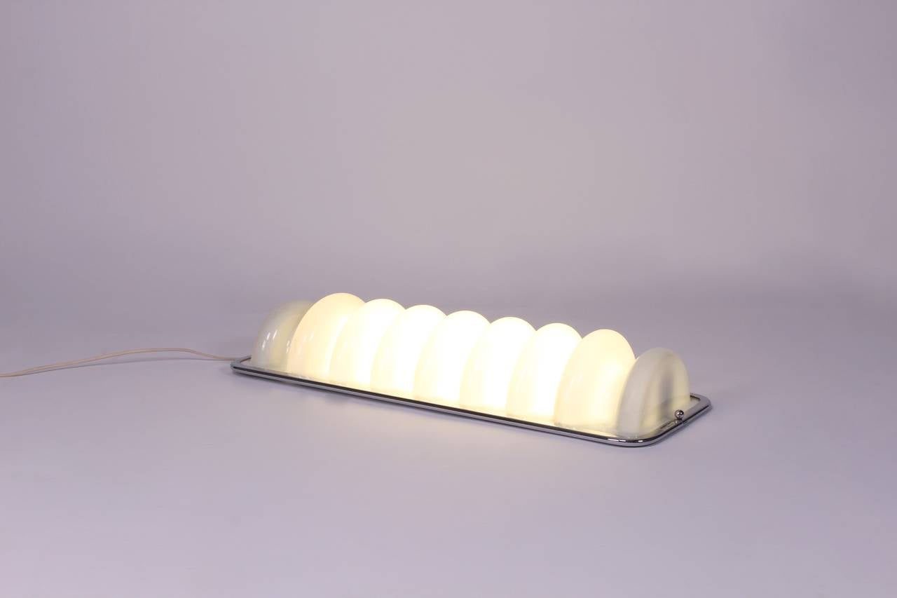 Ettore Sottsass.
Bruco wall lamp from the Mobili Grigi series,
Italy, 1971.
Manufactured by Design Centre and Poltronova.
Plastic, chrome-plated brass.
Dimension: 11 W x 5 D x 30.5 H inches.

https://en.wikipedia.org/wiki/Ettore_Sottsass for