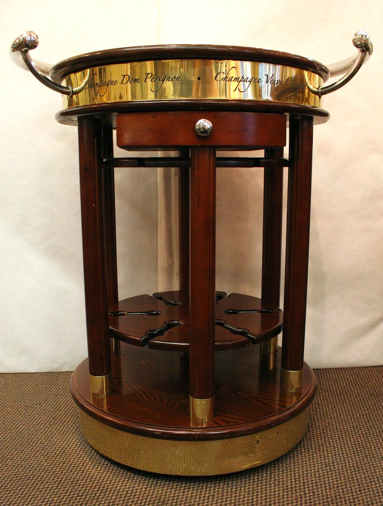 Fabulous unique piece. What a great addition to any residence. We all love champagne, and this great trolley has the names of the most famous vintages etched in brass around its border. Plenty of storage for your great glassware. Very unique and