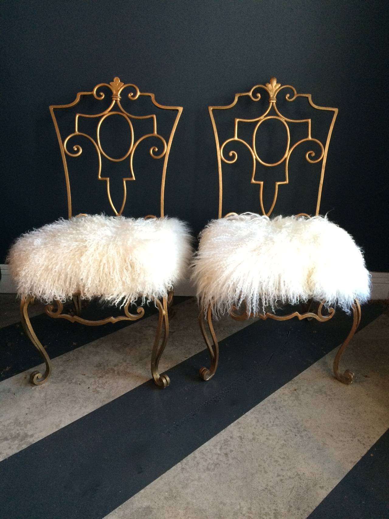 Exquisite wrought iron chairs by French designer, Jean-Charles Moreux wrought iron chairs, this duo have removable Mongolian fur cushions, low and sophisticated, a compliment to any room or outdoor with or without a cushion.