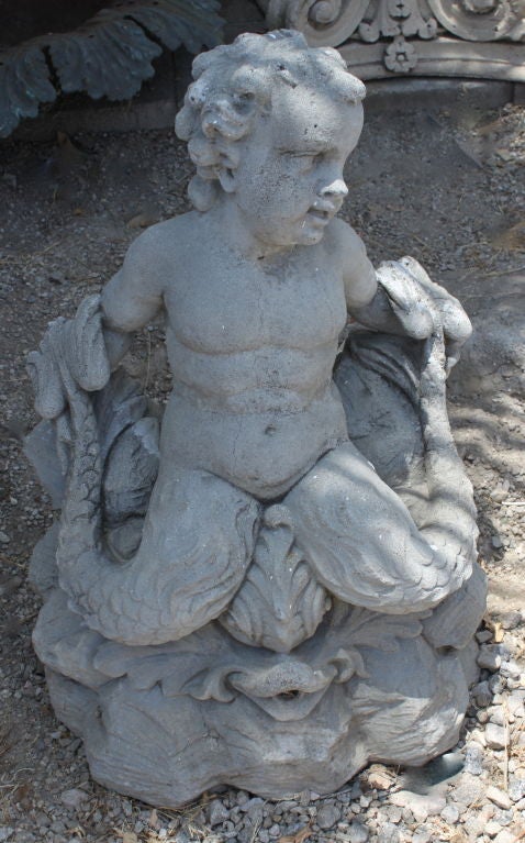 Made of concrete, a beautifully detailed merman rides a fish that spouts water into your surround or pool.